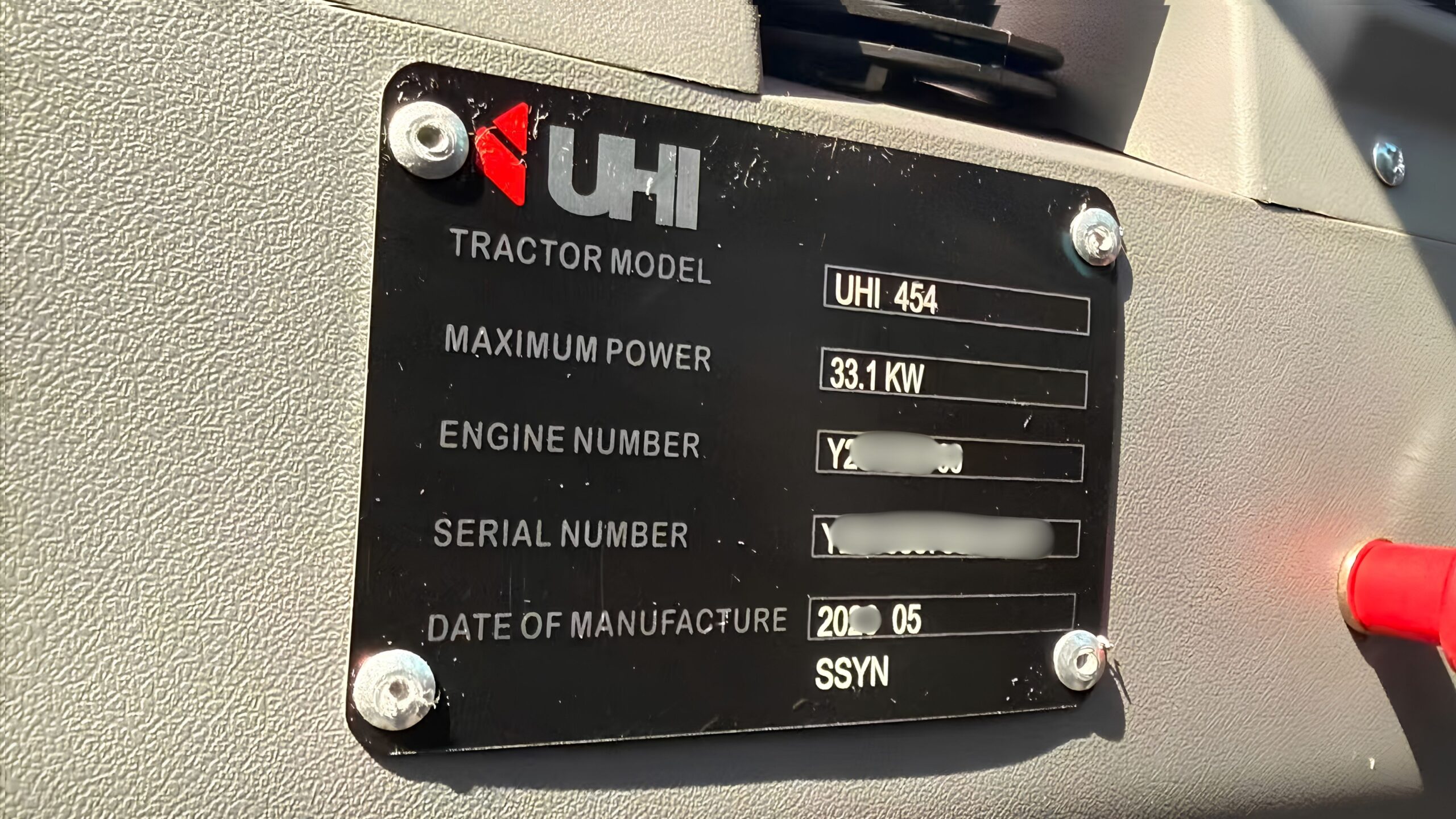 Technician locating the serial number plate on heavy machinery